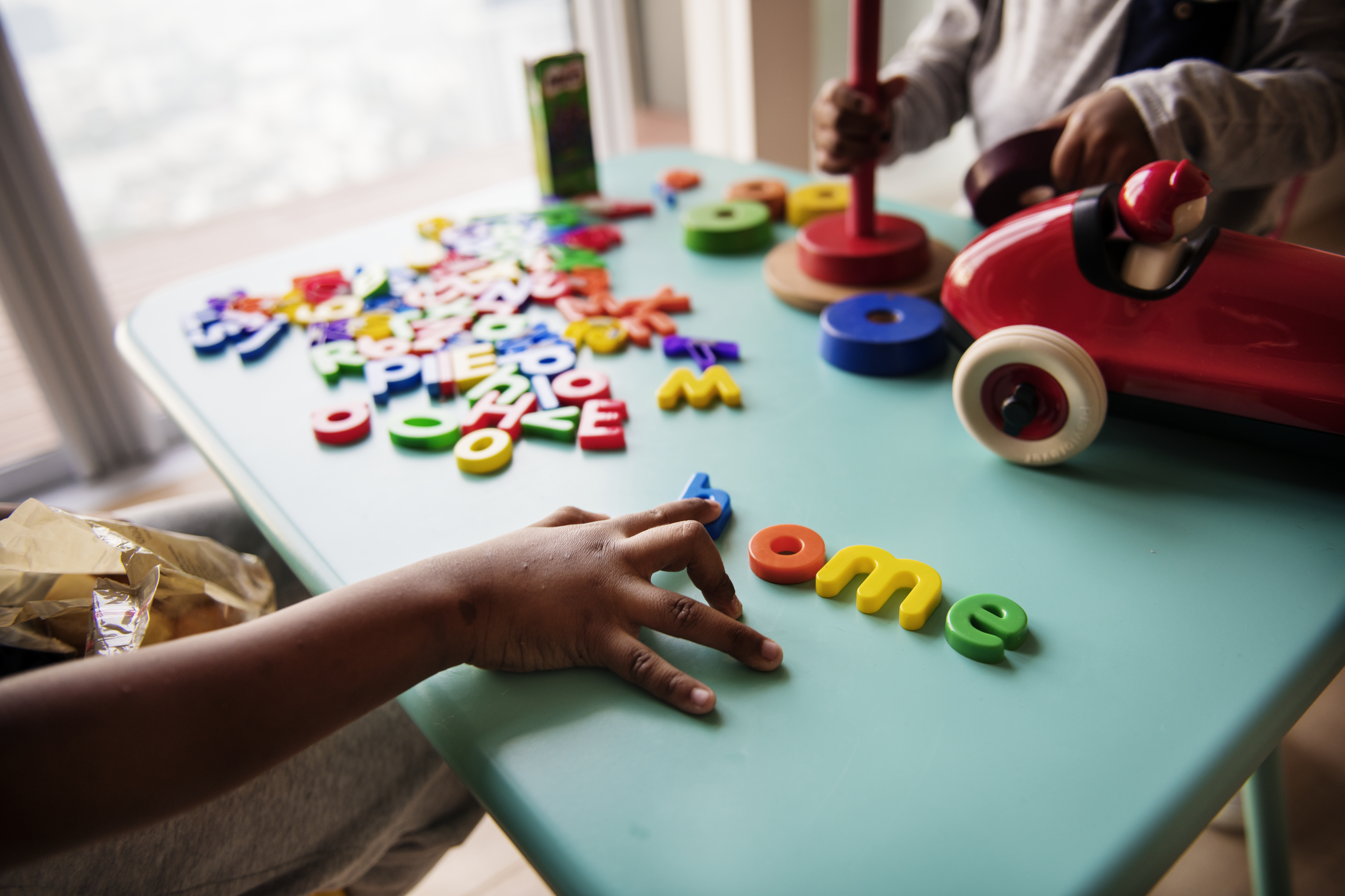 Colourful letter tiles and wooden toys on a classroom table
