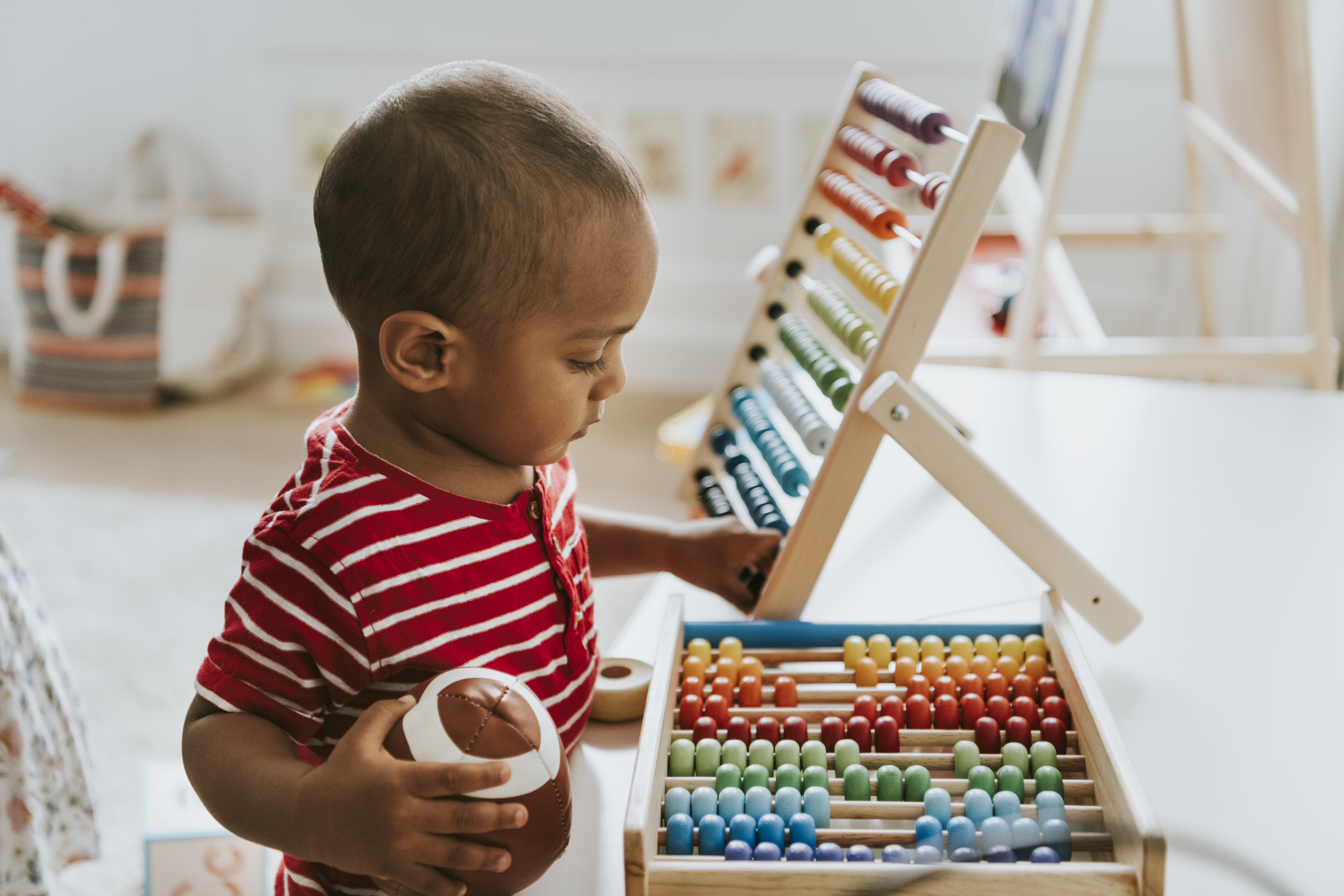 A happy toddler exploring wooden Montessori materials